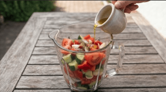 Gazpacho durch ein Sieb streichen