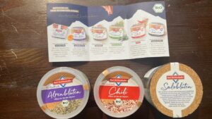 Bad Reichenhaller Fleur de Sel der Alpen: drei Bio-Salzsorten Alpenblüten, Chili und Salzblüten vor der Produktbroschüre